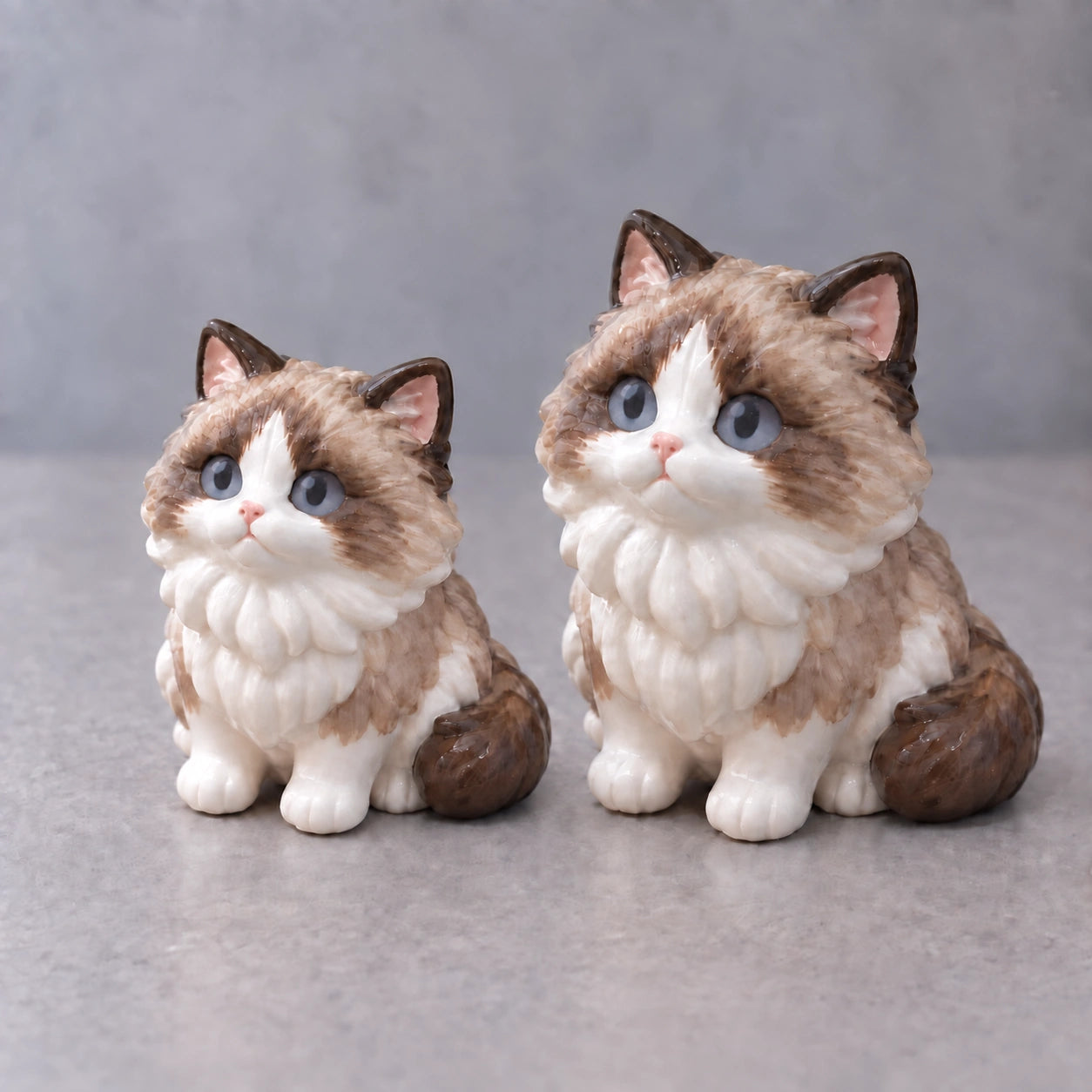 Illustrative side-by-side comparison: 2.4 inch and 3.1 inch versions of the same cat figurine