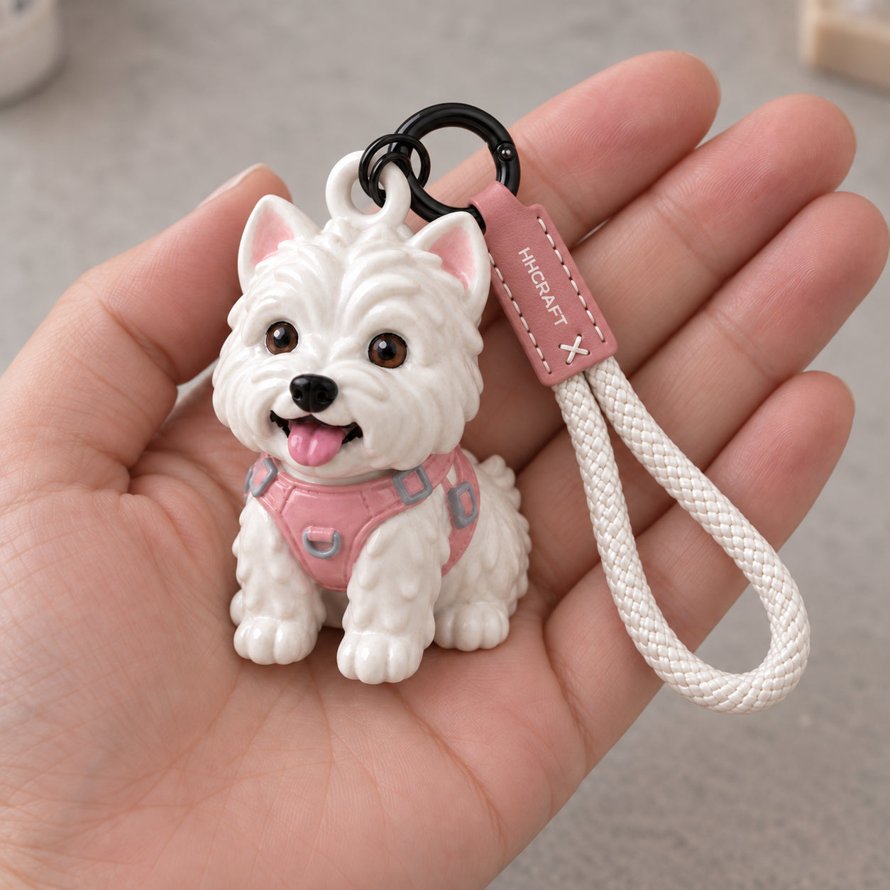Illustrative hand-painted Westie keychain resting in a palm, with individually painted brown eyes